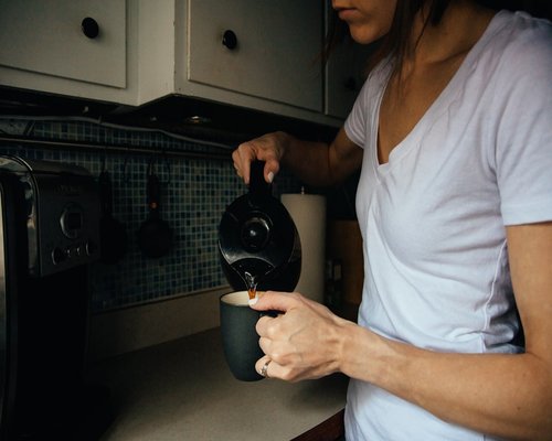 Person preparing a calm morning coffee in the kitchen