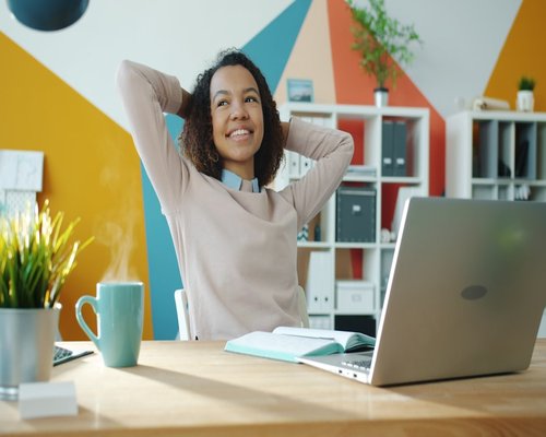 Woman taking a short break stretching arms at desk